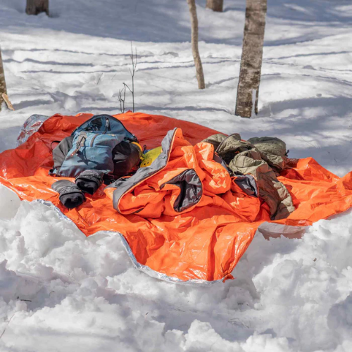 Emergency Blanket by SOL keep gear dry on the ground 